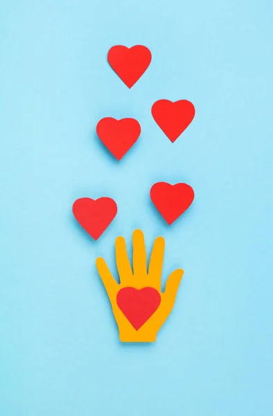 International Day of Charity, 5 September. Tolerance, kindness, cooperative, friendship, charity, humanitarian aid day concept. Colorful hands on blue background, copy space, top view.