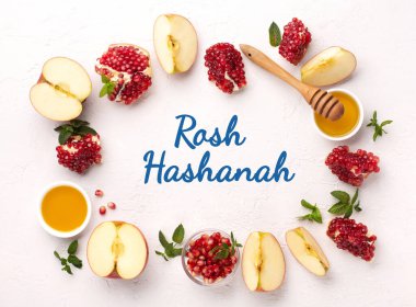 Rosh Hashanah, Jewish New Year Autumn Holiday Concept. Apples, Honey, Pomegranate, Traditional Products for Celebration on White Stone Background.