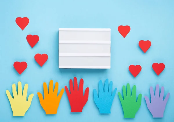 International Day of Charity, 5 September. Tolerance, kindness, cooperative, friendship, charity, humanitarian aid day concept. Colorful hands on blue background, copy space, top view.