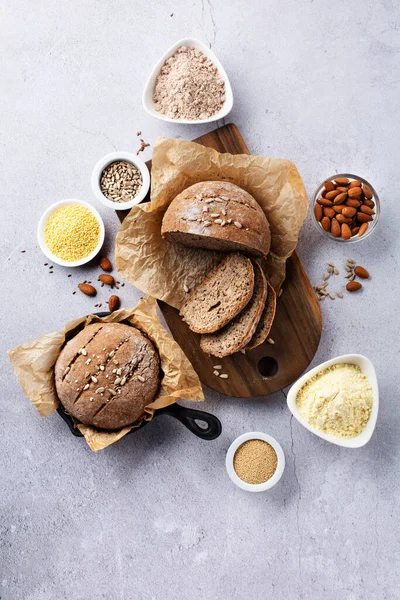 Gluten Free Homemade Bread. Healthy eating, dieting, balanced food concept. Cereals gluten-free, millet, quinoa, almond, buckwheat, flax seeds, sunflower seeds on grey background. Ancient grain food.