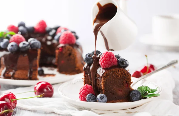 自家製のビーガングルテンフリーチョコレートケーキ新鮮なベリーと ラズベリー ブルーベリーと白い木製のテーブルの上の桜 健康食品 グルテンフリーフードコンセプト — ストック写真