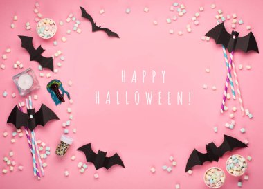 Mutlu Cadılar Bayramı konsepti. Cadılar Bayramı süslemeleri, kağıt siyah yarasalar, pembe arka planda şekerler. Cadılar Bayramı partisi tebrik kartı maketi, kopyalama alanı. Düz yatıyordu, üstten, yukarıdan..