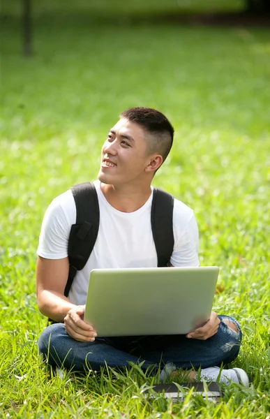 Jovem bonito asiático estudante usando laptop no parque — Fotografia de Stock