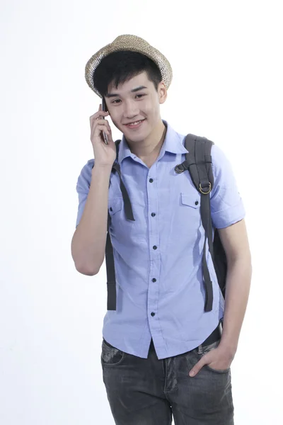 Portrait of a young Asian handsome student guy using internet on cellphone — Stock Photo, Image