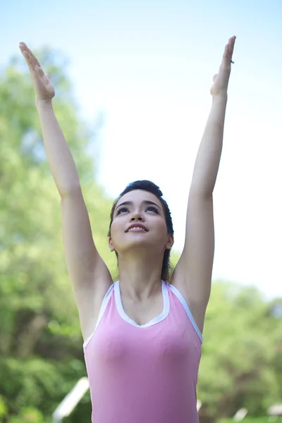 En ung vacker asiatisk kvinna gör yoga utanför i gröna — Stockfoto