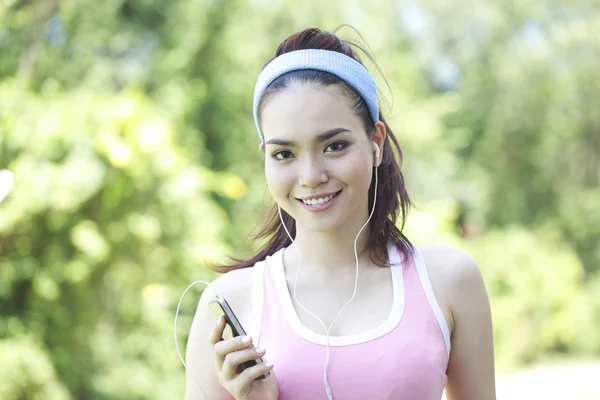Running Asian fitness sport woman jogging smiling happy in the park and listen to the music — Stock Photo, Image