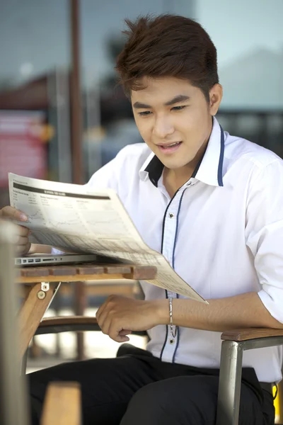 A asian student with newspaper outdoor — Stock Photo, Image