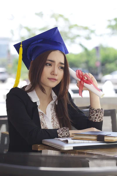 Portrait of a beautiful young asian woman in graduation uniform but sad — Stock Photo, Image