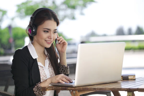 Uma mulher de negócios asiática bonita usando laptop ao ar livre — Fotografia de Stock
