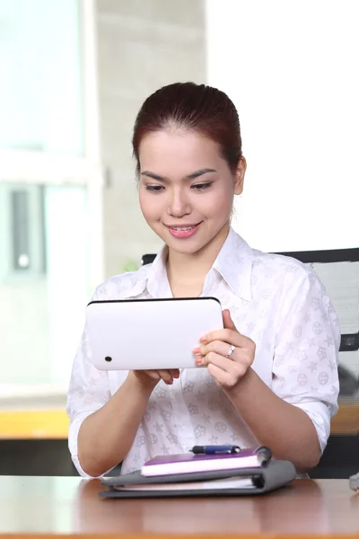 Portret van Aziatische jonge mooie vrouw met tablet pc in office en glimlach — Stockfoto