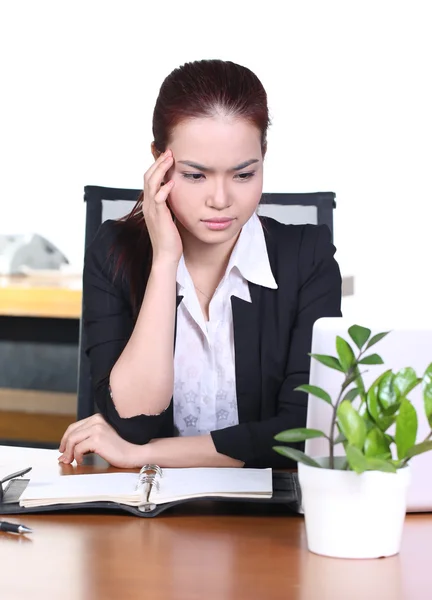 Kopfschmerzen und Stress am Arbeitsplatz. junge professionelle Frau sitzt gestresst und müde mit Kopfschmerzen am Schreibtisch und hält Medikamententabletten in der Hand — Stockfoto