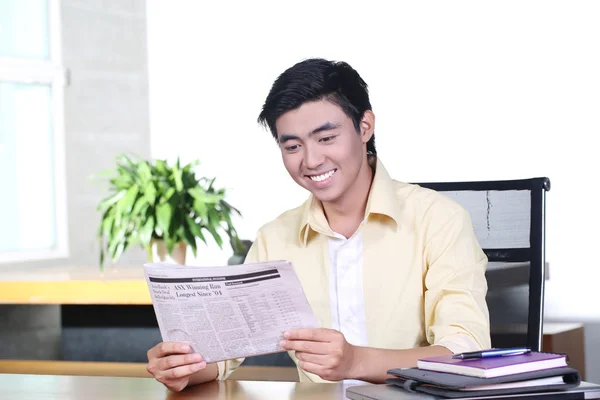 Szczęśliwy azjatycki biznes młody człowiek czyta gazety i uśmiech — Zdjęcie stockowe