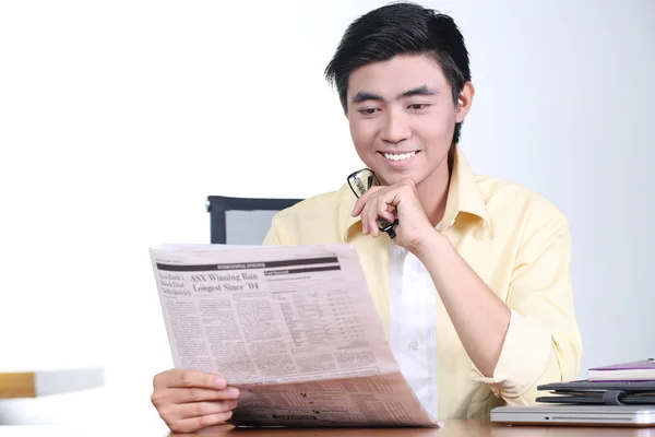 Happy asian pemuda pebisnis membaca koran dan tersenyum — Stok Foto