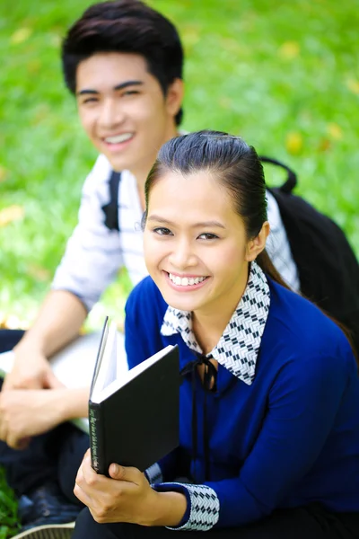 Jeunes étudiants asiatiques avec des livres et sourire en plein air — Photo