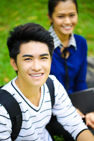 Giovani studenti asiatici con computer e sorriso all'aperto — Foto Stock