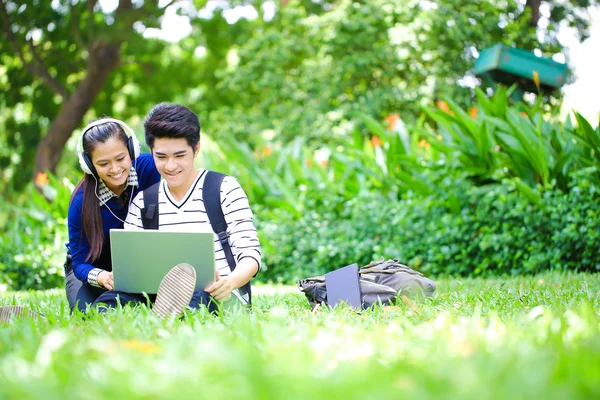 Jóvenes estudiantes asiáticos con computadora y sonrisa al aire libre — Foto de Stock