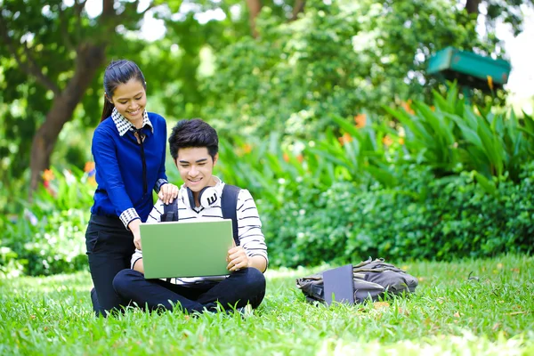 Young Asian students with computer and smile in outdoor — Zdjęcie stockowe