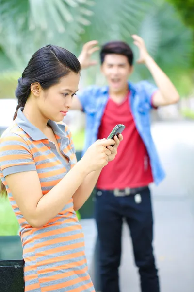 用手机在户外对亚洲年轻夫妇 — 图库照片