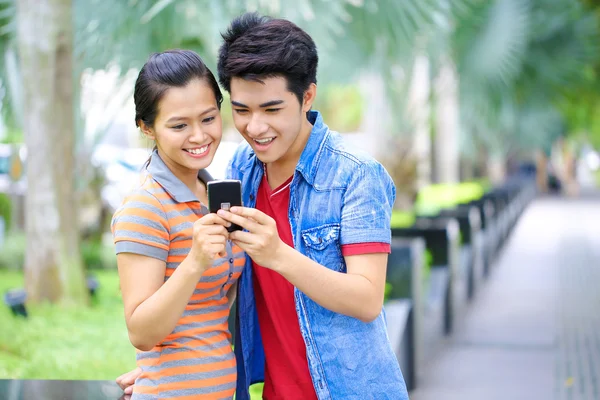Joven pareja asiática con teléfono en al aire libre —  Fotos de Stock