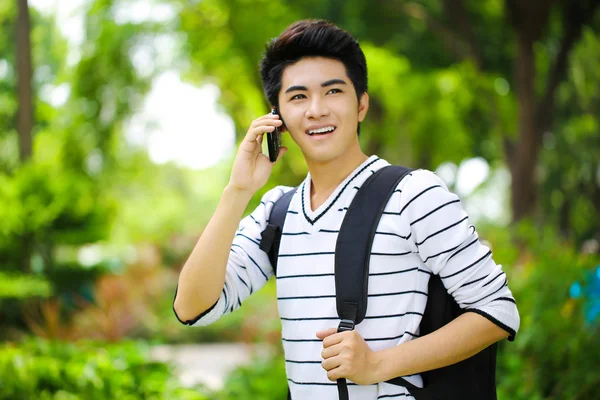 年轻英俊的亚洲学生用手机在户外 — 图库照片