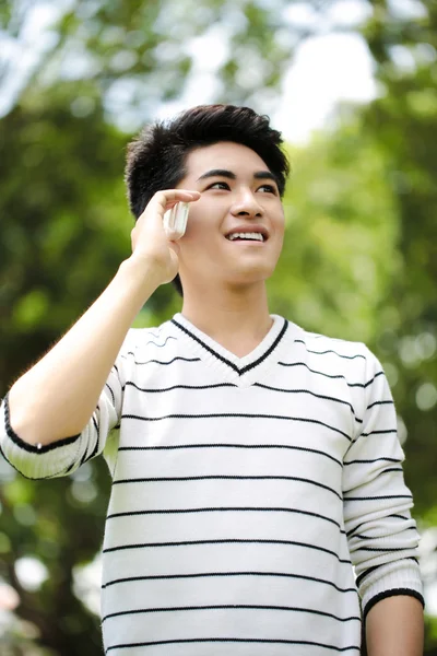 年轻英俊的亚洲学生用手机在户外 — 图库照片