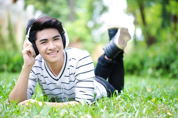 Giovane bello asiatico studente con headset fuori porta — Foto Stock