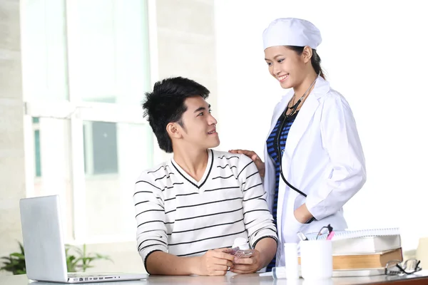 Азиатская молодая женщина врач проверяет пациента — стоковое фото