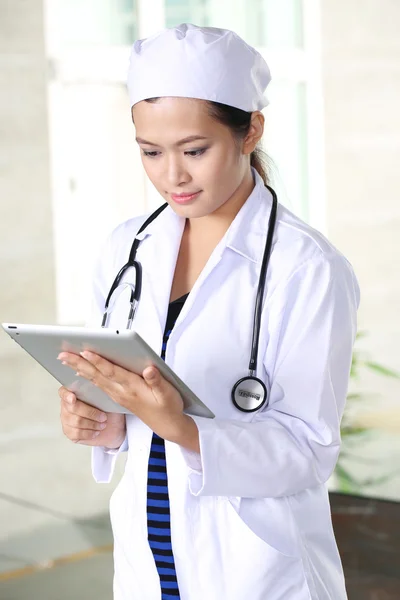 Chirurg Frau Arzt Lächeln mit Tablet-PC im Krankenhaus, Modell ist eine asiatische Schönheit — Stockfoto