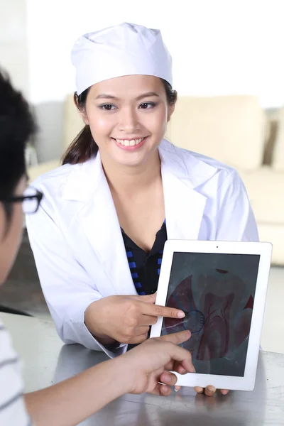 Азиатская молодая женщина врач проверяет пациента — стоковое фото