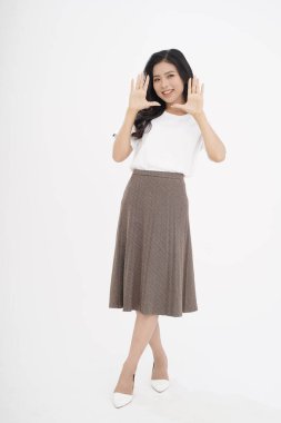 Asyalı çekici genç bir kadın, el hareketleriyle, fotokopi odasında parmağını gösteriyor, arka planda soyutlanmış.