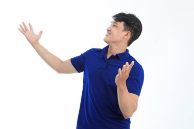 Polo tişörtlü Asyalı genç adam beyaz arka planda el hareketi ve yüz ifadesiyle izole edilmiş.