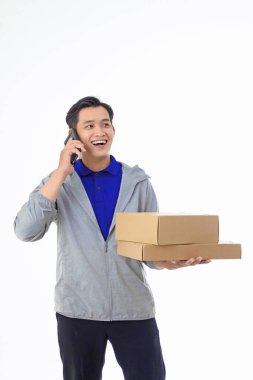Asyalı yakışıklı ve neşeli teslimatçı, arka planda izole edilmiş.