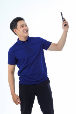 Yaka gömlekli Asyalı genç adam beyaz arka planda el hareketi ve yüz ifadesiyle izole edilmiş.