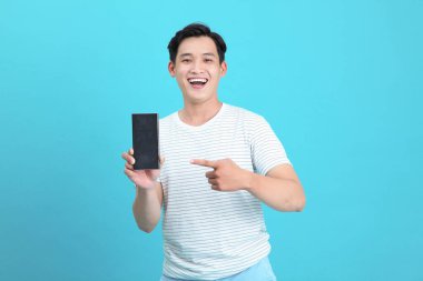 Asyalı yakışıklı ve neşeli genç adam, arka planda soyutlanmış.