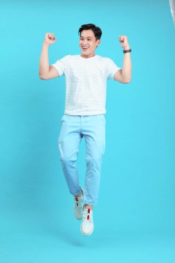 Asyalı yakışıklı ve neşeli genç adam, arka planda soyutlanmış.