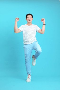 Asyalı yakışıklı ve neşeli genç adam, arka planda soyutlanmış.