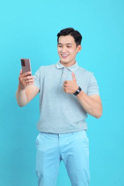 Asyalı yakışıklı ve neşeli genç adam, arka planda soyutlanmış.