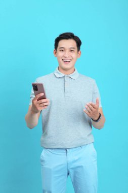 Asyalı yakışıklı ve neşeli genç adam, arka planda soyutlanmış.