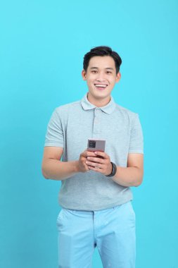 Asyalı yakışıklı ve neşeli genç adam, arka planda soyutlanmış.