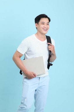 Asyalı yakışıklı ve neşeli genç adam, arka planda soyutlanmış.