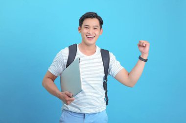 Asyalı yakışıklı ve neşeli genç adam, arka planda soyutlanmış.