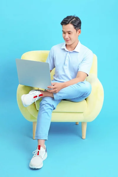 Azjatycki Przystojny Wesoły Młody Człowiek Pracuje Laptopie Siedzi Kanapie Odizolowany — Zdjęcie stockowe