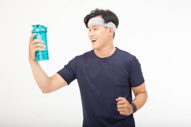 Asyalı yakışıklı genç, sportif ve neşeli adam, beyaz arka planda soyutlanmış.