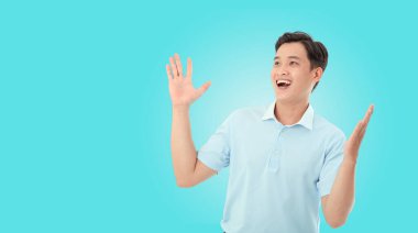 Asyalı yakışıklı ve neşeli genç adam. El hareketleriyle fotokopi alanını işaret ediyor. Arka planda izole edilmiş.