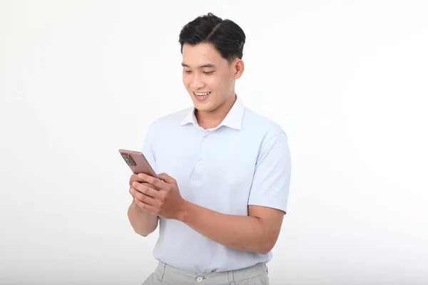 亚洲英俊的年轻人 性格开朗 手里拿着智能手机 背景是白色的 — 图库照片