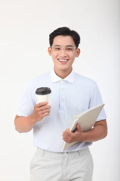 アジアのハンサムな若いと陽気な男は白い背景に隔離されたコーヒーのノートと紙のカップを保持します — ストック写真