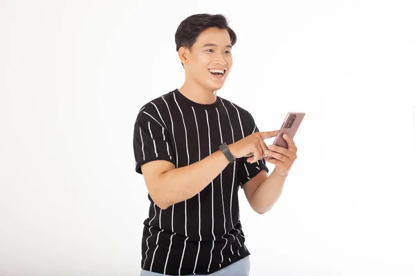 アジアのハンサムな若いと陽気な男は 白い背景に隔離されたスマートフォンを保持します — ストック写真