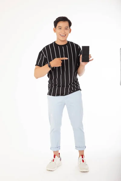 纵横交错的照片 全身上下都是一位年轻而快乐的亚裔男子 手持智能手机 与白色背景隔离 — 图库照片#