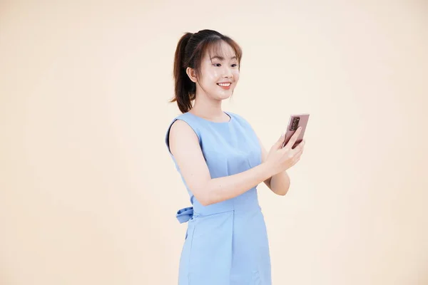 アジアの若い美しいと陽気な女性の肖像 スマートフォンを使用して 背景に隔離された — ストック写真