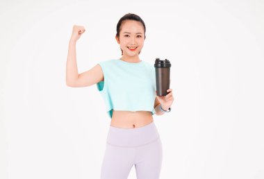 Asyalı genç, güzel ve neşeli bir kadının portresi. Elinde sallama şişesi, arka planda izole edilmiş.